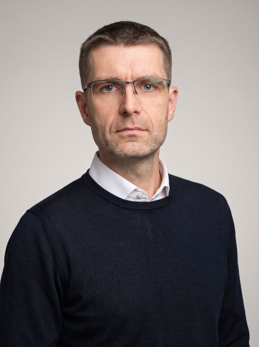 Roman Klein v tmavém svetru přes bílou košili